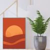 Decorative wall art with a sunset design on an orange background