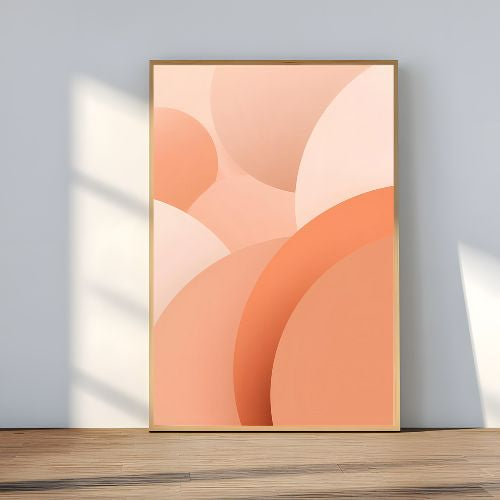 Framed abstract art with peach and orange colors on a light gray wall.