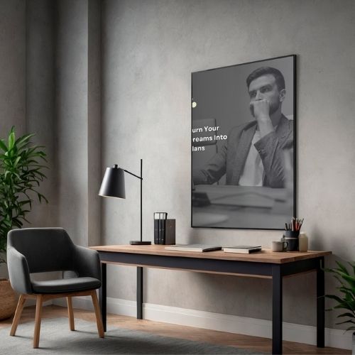 Modern home office with a desk, chair, lamp, and motivational poster on a gray wall.